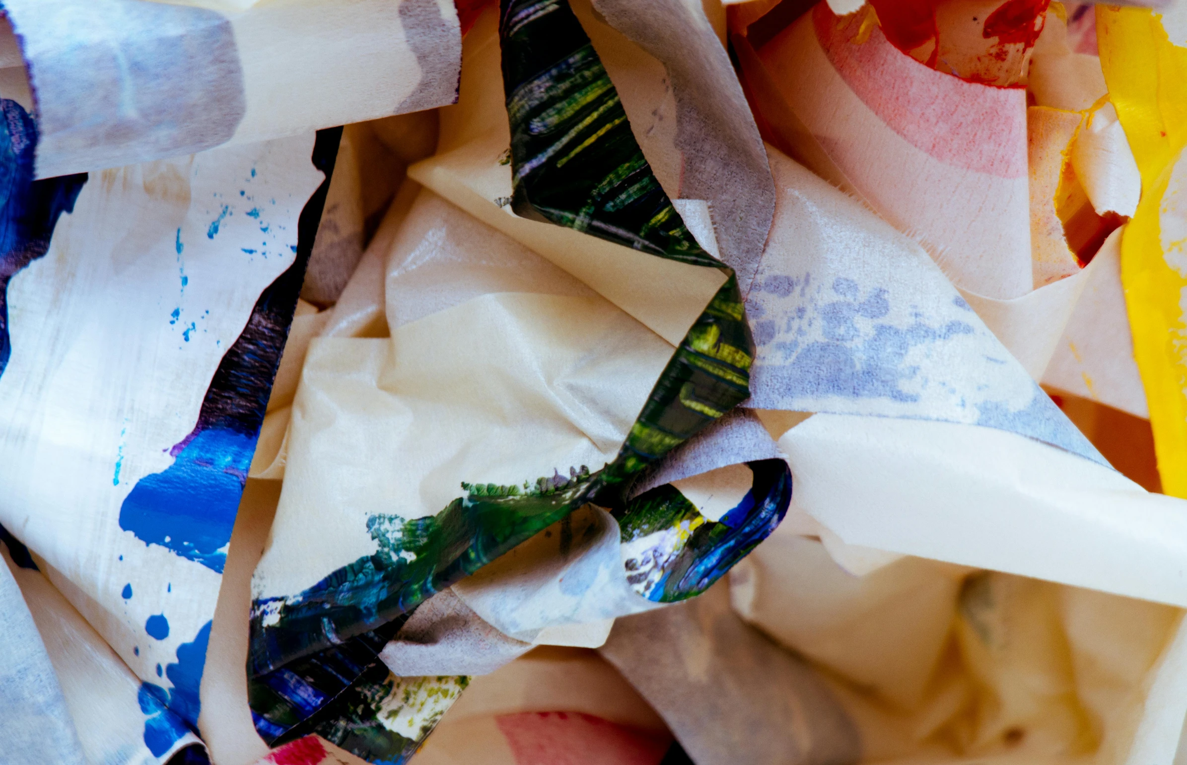 a pile of torn paper sitting on top of a table, inspired by John Chamberlain, unsplash, process art, wide ribbons, colourful close up shot, plastic wrap, bottom body close up