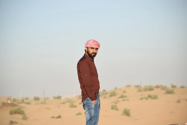 a man standing on a skateboard in the desert, by Ismail Acar, les nabis, profile pic, brown stubble, group photo, vastayan
