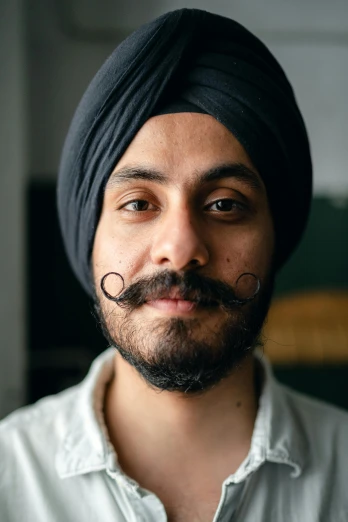 a close up of a person wearing a turban, by Manjit Bawa, handlebar mustache, long pointy ears, lovingly looking at camera, andrew gonzalez