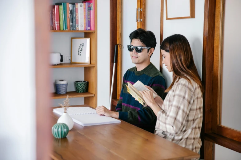 a man and a woman sitting at a table, by Jang Seung-eop, pexels contest winner, reading glasses, casually dressed, at home, wearing shades