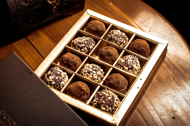 a box of chocolates sitting on top of a wooden table, by Julia Pishtar, renaissance, luscious with sesame seeds, professionally assembled, thumbnail, black