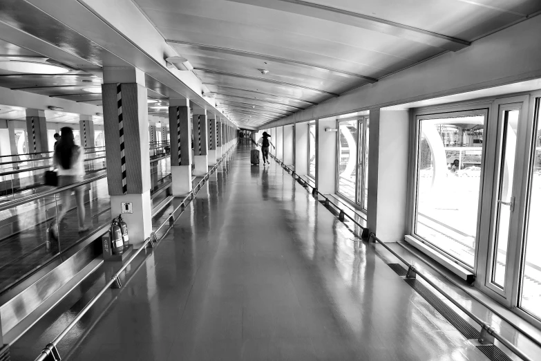 a black and white photo of people on an escalator, a black and white photo, pexels, minimalism, on aircraft carrier, beautiful futuristic new delhi, rows of doors, hallway landscape