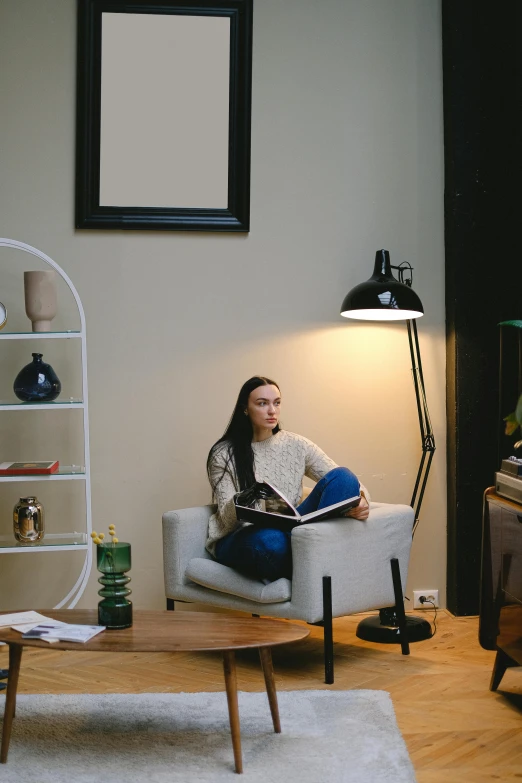 a woman sitting in a chair reading a book, a portrait, pexels contest winner, modernism, emerging from her lamp, teenager hangout spot, tv still frame, high quality photo