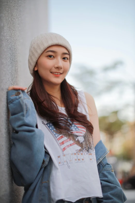 a woman leaning against a wall wearing a hat, inspired by Kim Jeong-hui, trending on pexels, photorealism, wearing a beanie, young cute wan asian face, wearing a vest top, avatar image