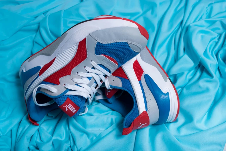 a close up of a pair of shoes on a bed, trending on dribble, blue and red, based on a puma, streetwear, exhilarated