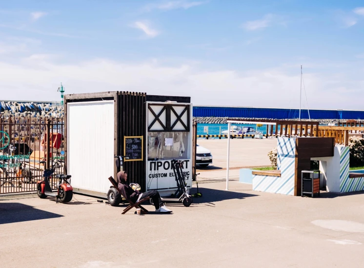 a man sitting on a motorcycle in a parking lot, by Julia Pishtar, temporary art, beach bar, cube portals, black sea, gigapixel photo