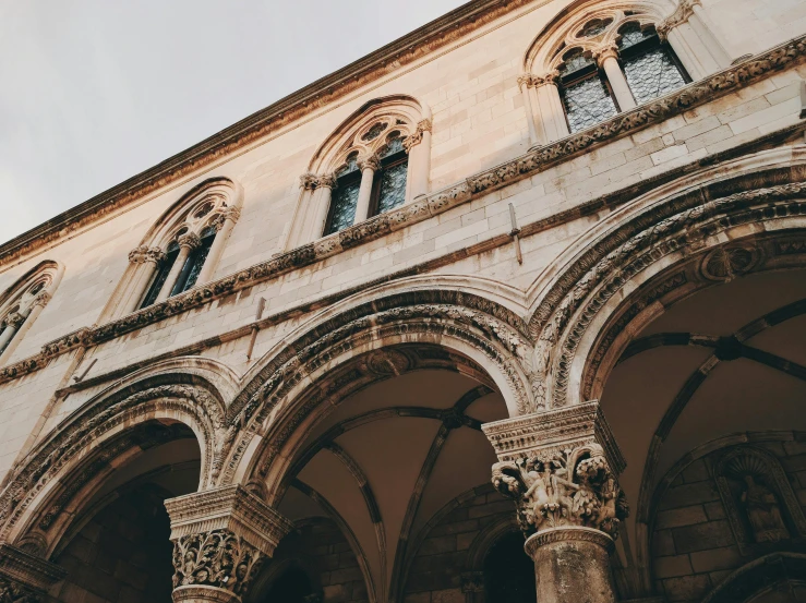 a tall building with a clock on top of it, unsplash contest winner, romanesque, dry archways, dubrovnik, 🎨🖌️, carved marble
