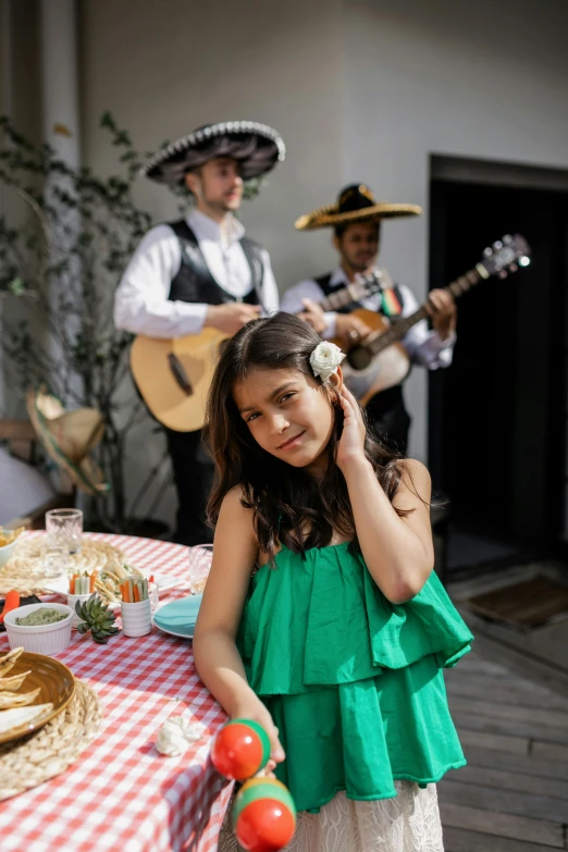 a little girl standing in front of a table with food, an album cover, pexels contest winner, happening, beautiful mexican woman, musicians, al fresco, fancy dress