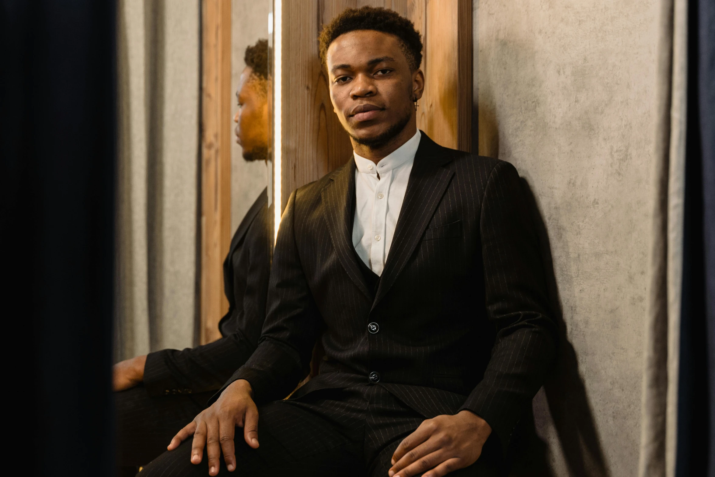 a man in a suit sitting on a chair, by Frank Mason, pexels contest winner, renaissance, black teenage boy, young man with beautiful face, three piece suit, reflecting