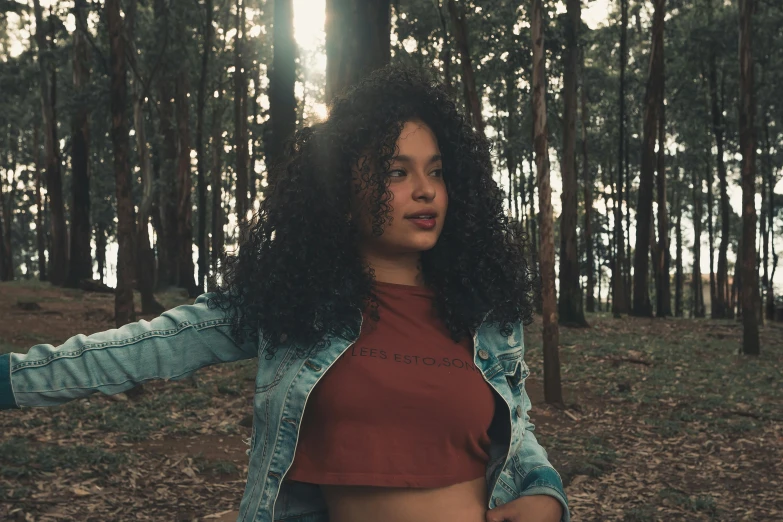 a woman standing in a forest holding a frisbee, inspired by Elsa Bleda, pexels contest winner, renaissance, curly afro, wearing a sexy cropped top, teenage girl, brown clothes