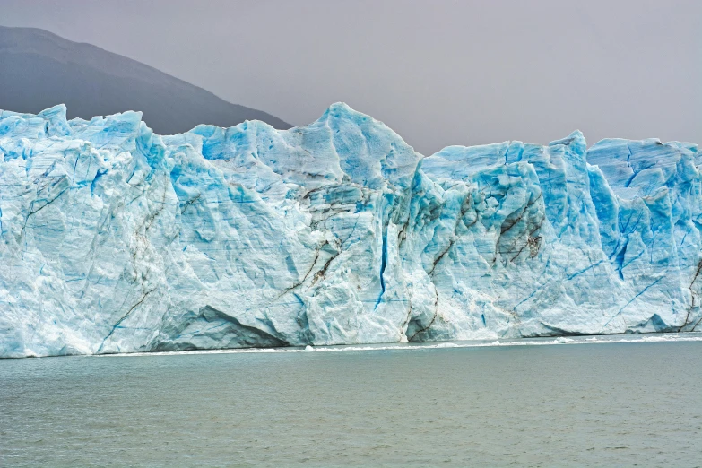 a large iceberg in the middle of a body of water, by Alison Geissler, pexels contest winner, hyperrealism, patagonian, 2 0 2 2 photo, fan favorite, cold colors