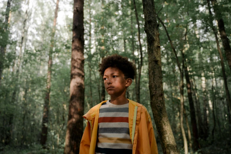 a young boy standing in the middle of a forest, pexels contest winner, portrait of willow smith, yellow clothes, wes anderson movie, photographed for reuters