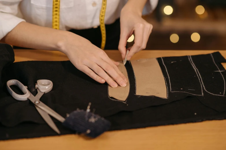 a person cutting a piece of fabric with a pair of scissors, a cartoon, inspired by René Burri, trending on pexels, corsets, brown, black, navy