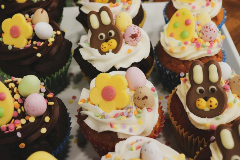 a white plate topped with cupcakes covered in frosting, a cartoon, pexels, easter, 2 0 0 0's photo