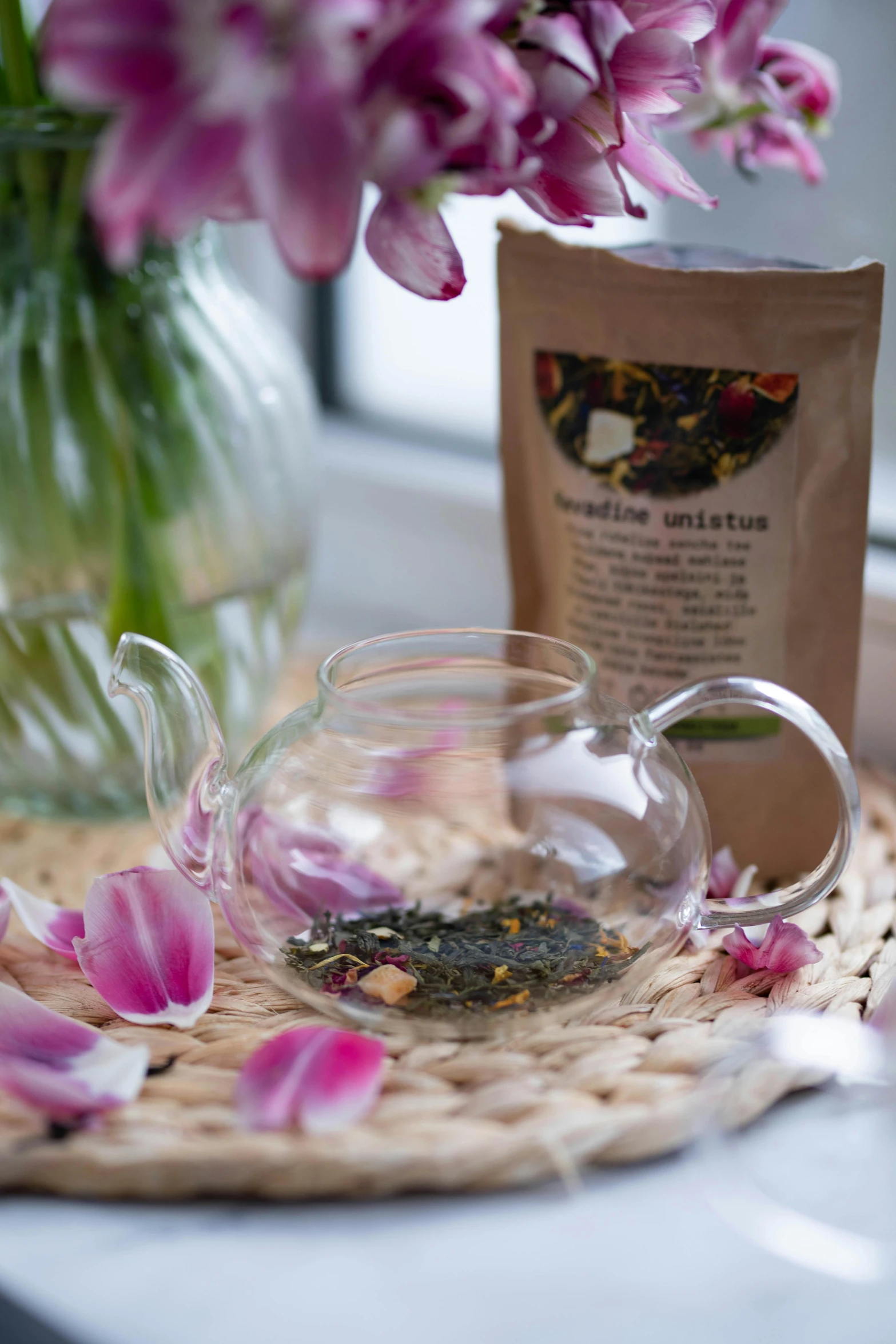 a cup of tea sitting on top of a table next to a vase of flowers, seeds, product shot, teapot, unwind!