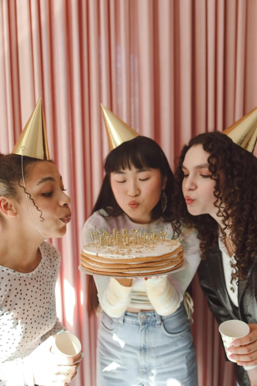 three women blowing out candles on a cake, an album cover, trending on pexels, happening, pointy hat, bella poarch, rebecca sugar, vsco