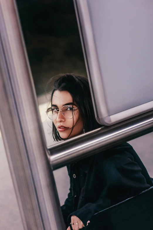 a woman sitting on a bus looking out the window, inspired by Elsa Bleda, trending on pexels, square glasses, madison beer girl portrait, in doors, androgynous face