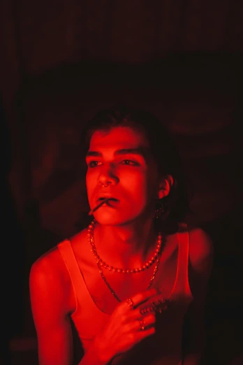 a woman smoking a cigarette in a dark room, an album cover, inspired by Elsa Bleda, trending on pexels, bauhaus, red monochrome, lil peep, bisexual lighting, color 3 5 mm