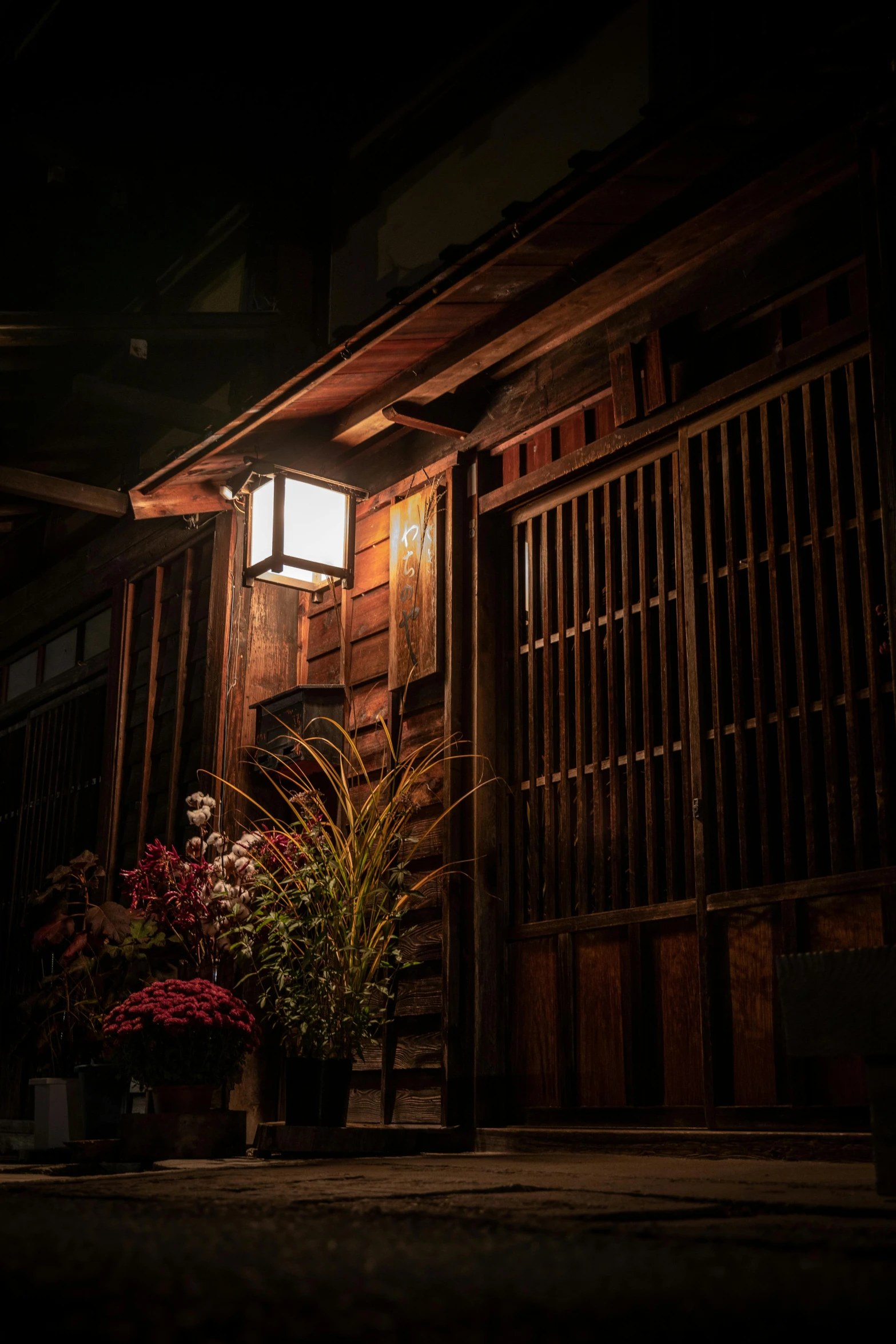 a street light sitting on the side of a building, shin hanga, dimly lit cozy tavern, flowers around, yasuke 5 0 0 px models, brown