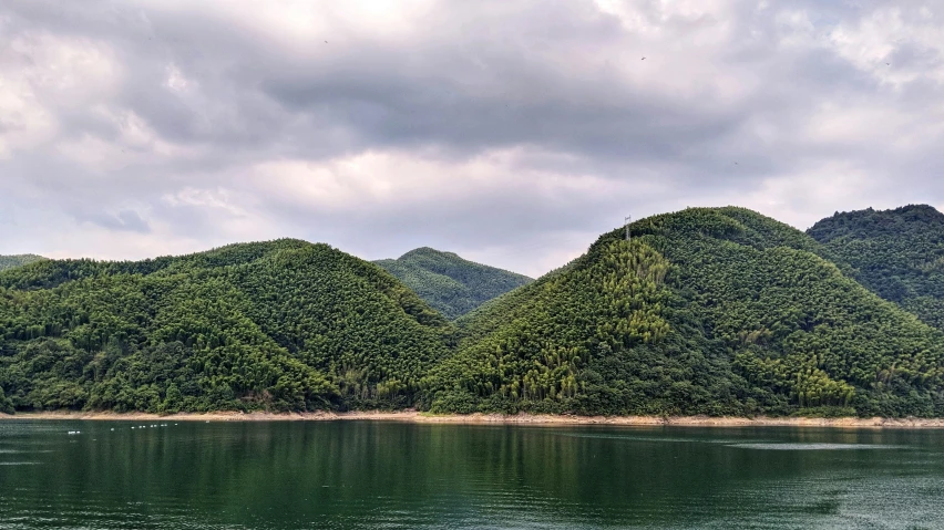 a large body of water with mountains in the background, by Kim Tschang Yeul, pexels contest winner, sōsaku hanga, forest green, jiyun chae, 2000s photo, photo on iphone