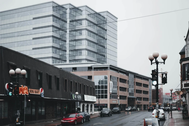 a city street filled with lots of traffic next to tall buildings, by Washington Allston, renaissance, industrial architecture, full of clear glass facades, espoo, desaturated