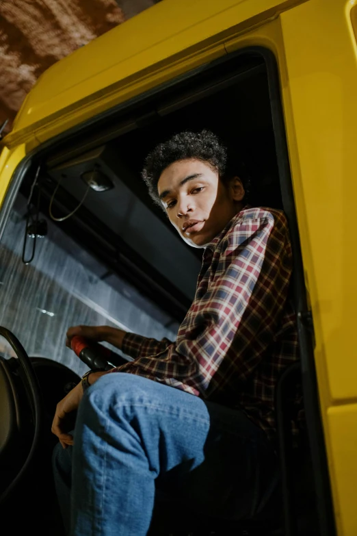 a man sitting in the driver's seat of a yellow truck, pexels contest winner, renaissance, portrait of 1 5 - year - old boy, promotional image, ashteroth, mid body shot