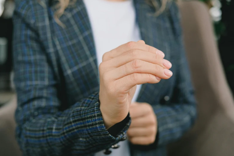 a close up of a person holding a cell phone, wearing a blazer, partially cupping her hands, background image, wearing a cardigan