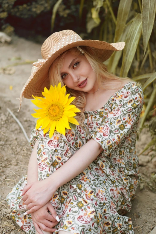 a woman sitting on the ground with a sunflower in her hand, instagram, renaissance, wearing wide sunhat, portrait image, blond, official screenshot