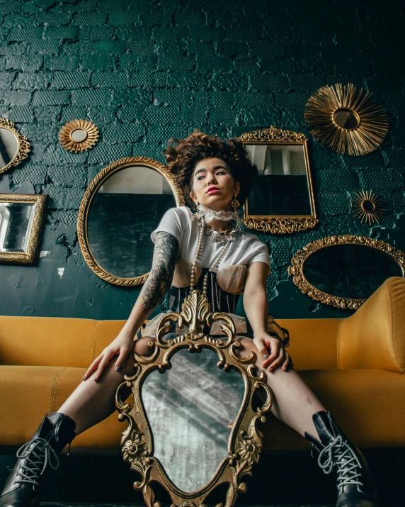 a woman sitting on a couch in front of a mirror, unsplash contest winner, maximalism, corsets, ashteroth, portrait androgynous girl, framed in image