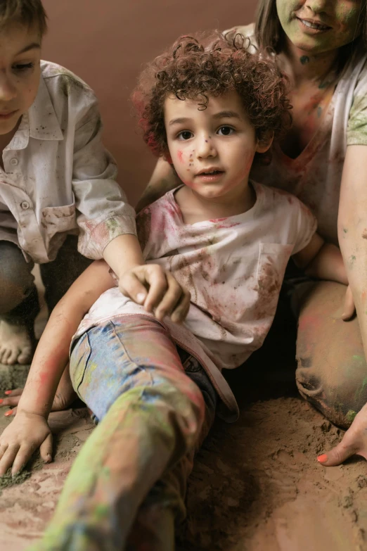 a woman and two children sitting next to each other, pexels contest winner, gutai group, muddy colors, hugging his knees, multicolor, distressed paint