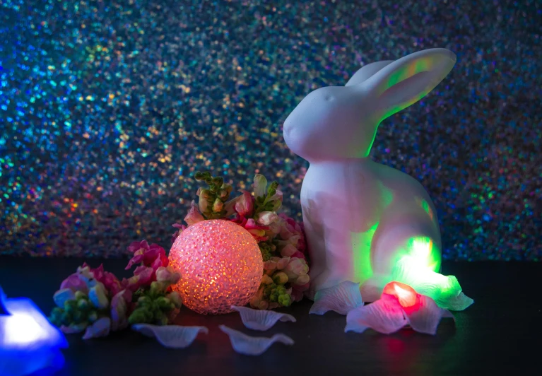 a white rabbit sitting on top of a table next to a light, a hologram, inspired by Peter Alexander Hay, candy decorations, multicoloured, lights with bloom, detailed product shot
