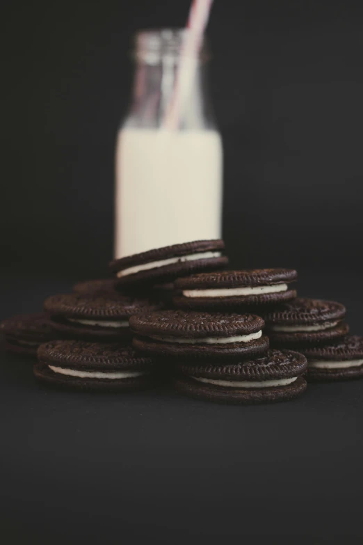 a pile of cookies next to a bottle of milk, a black and white photo, by Ben Zoeller, pexels, 15081959 21121991 01012000 4k, ( ultra realistic, milkshake, black velvet