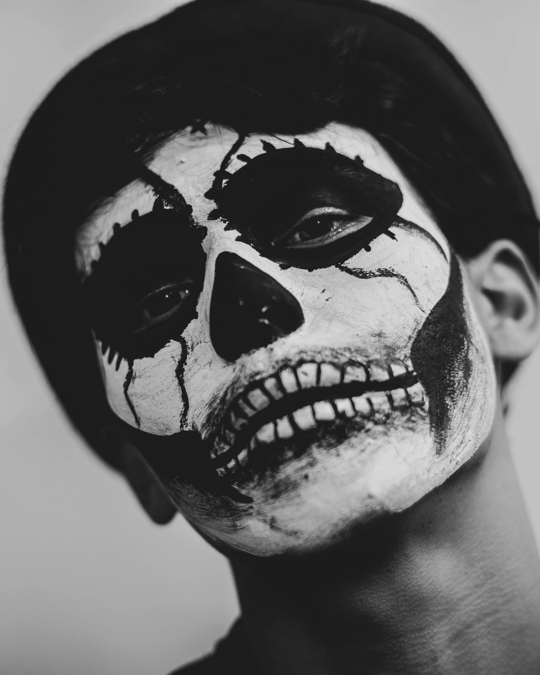 a man with a skull painted on his face, a black and white photo, pexels contest winner, drag queen, teenage boy, skull cap, lgbtq