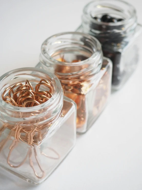 a couple of jars sitting on top of a table, copper spiral hair decorations, detail shot, squares, 2019 trending photo