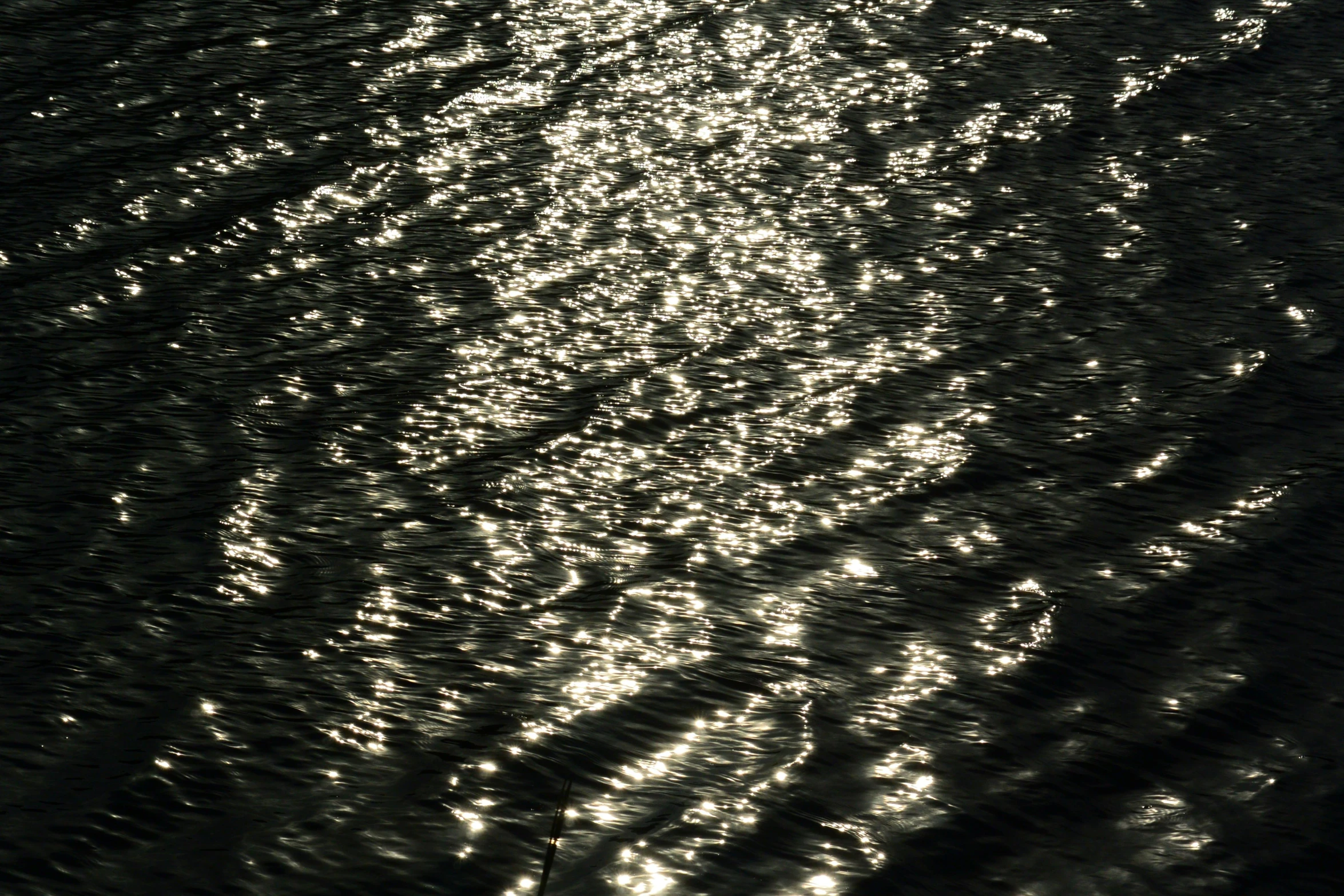 a black and white photo of a body of water, inspired by Andreas Gursky, gold dappled lighting, refracted sparkles, colour photograph, evening sunlight