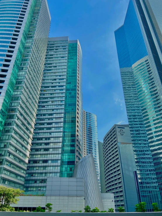 a group of tall buildings sitting next to each other, manila, aquamarine windows, tokio, high-quality photo