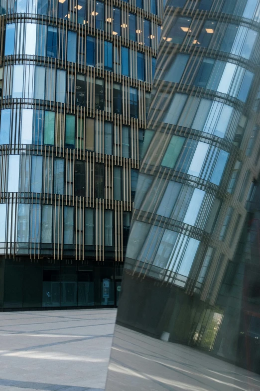 a man riding a skateboard down a street next to a tall building, inspired by Zaha Hadid, flickr, window glass reflecting, zoomed in, coventry city centre, sustainable architecture