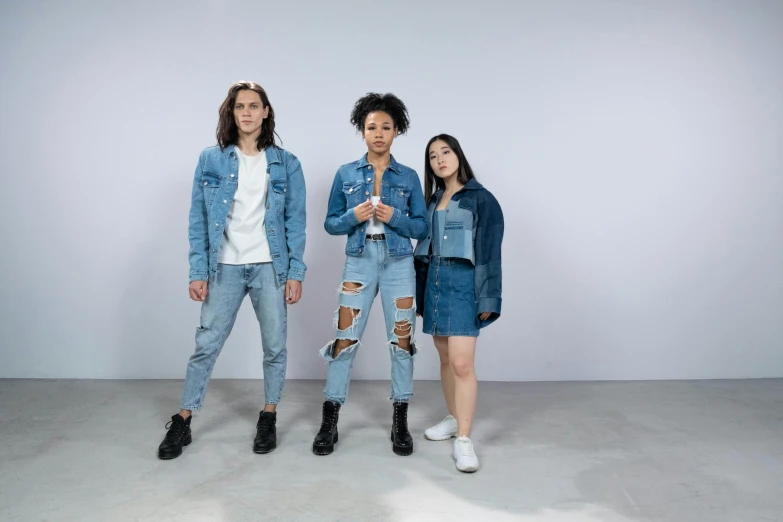 a group of three women standing next to each other, trending on pexels, antipodeans, wearing a jeans jackets, genderless, official store photo, wearing ragged clothing