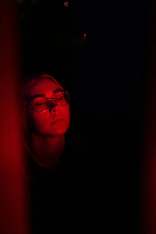 a woman with glasses in a dark room, inspired by Elsa Bleda, red reflective lens, black on red, high school, cinematic shot ar 9:16 -n 6 -g