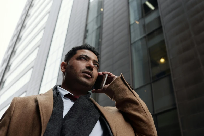 a man in a suit talking on a cell phone, a photo, pexels, towering, riyahd cassiem, rectangle, 1 2 9 7