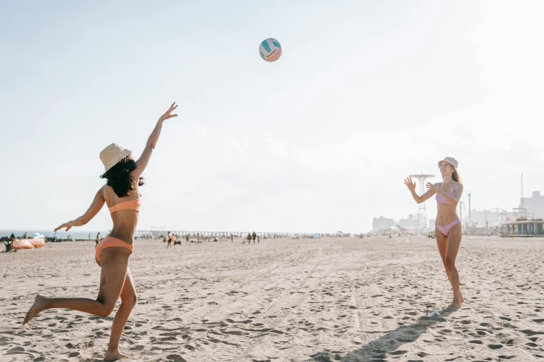two women playing with a ball on the beach, unsplash contest winner, santa monica beach, slightly tanned, wearing spandex bikini, 🚿🗝📝