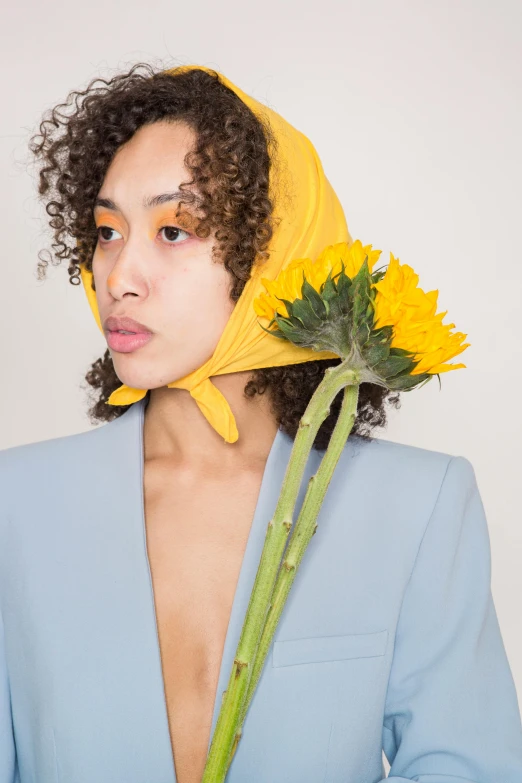 a woman with a sunflower in her hair, an album cover, inspired by Jean-Étienne Liotard, trending on pexels, imaan hammam, wearing pointed hoods, portrait sophie mudd, outfit photograph