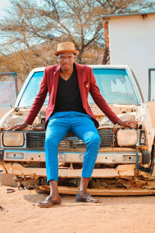 a man sitting on the hood of a car, an album cover, by Terese Nielsen, pexels contest winner, osborne macharia, elegantly dressed, shaven, emma uber