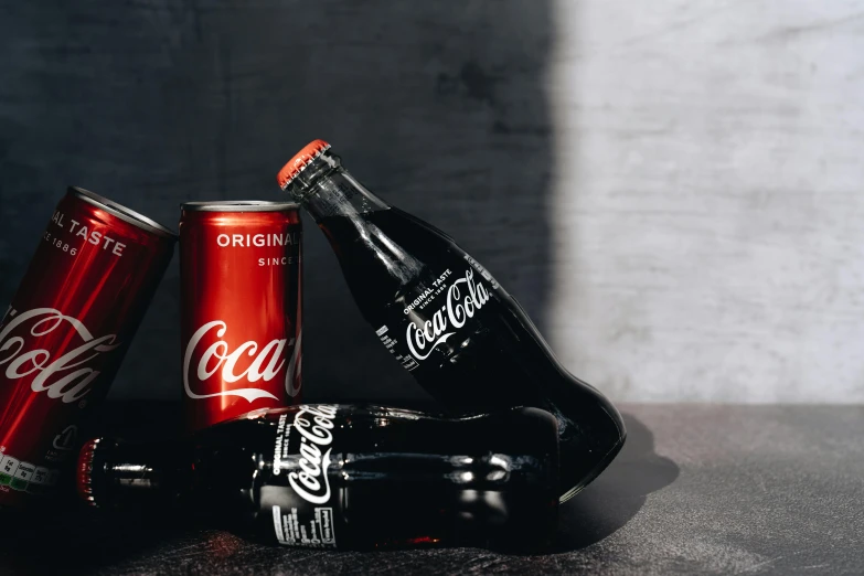 a group of coca colas sitting on top of a table, by Carey Morris, pexels contest winner, black and red, on a gray background, high contrast of light and dark, listing image