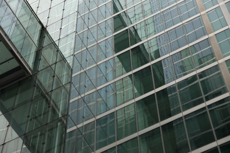 a tall glass building with a clock in front of it, inspired by Richard Wilson, unsplash, [ 4 k photorealism ], detail structure, large green glass windows, tungsten