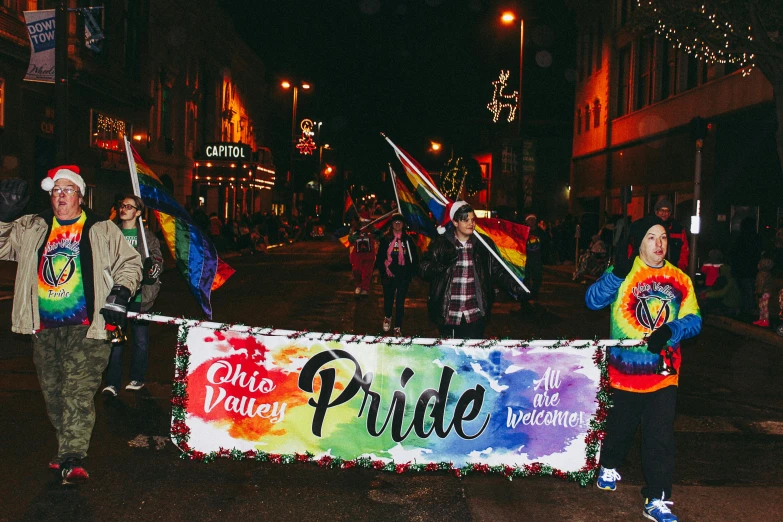 a group of people walking down a street at night, pride, banner, fully decorated, owsley