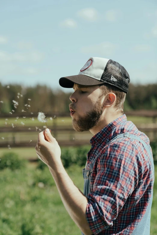 a man blowing a dandelion in a field, by Chase Stone, wearing cowboy hat, wearing a red lumberjack shirt, bubbles in the air, profile image