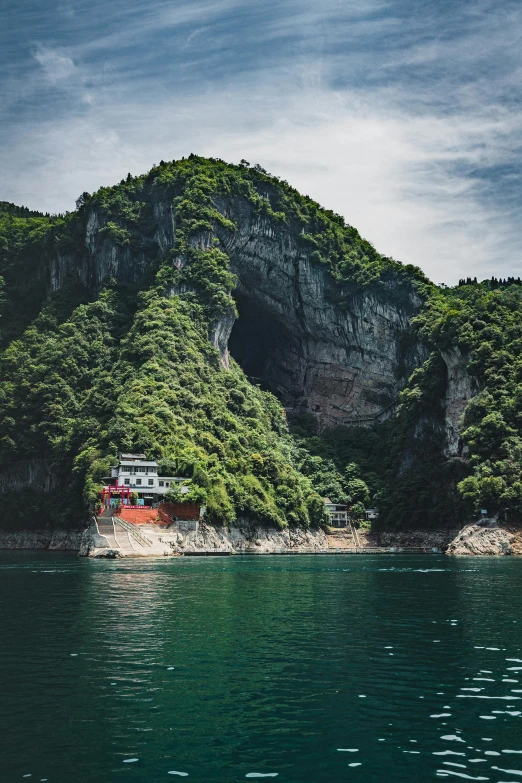 a boat in the middle of a body of water, inspired by Li Keran, pexels contest winner, empty bathhouse hidden in a cave, steep cliffs, color photo, high detailed photo