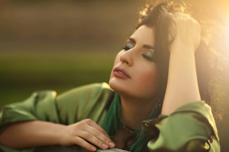 a beautiful woman laying on top of a wooden bench, an album cover, inspired by Elsa Bleda, trending on pexels, hurufiyya, in gentle green dawn light, beautiful iranian woman, gold and green, sundown