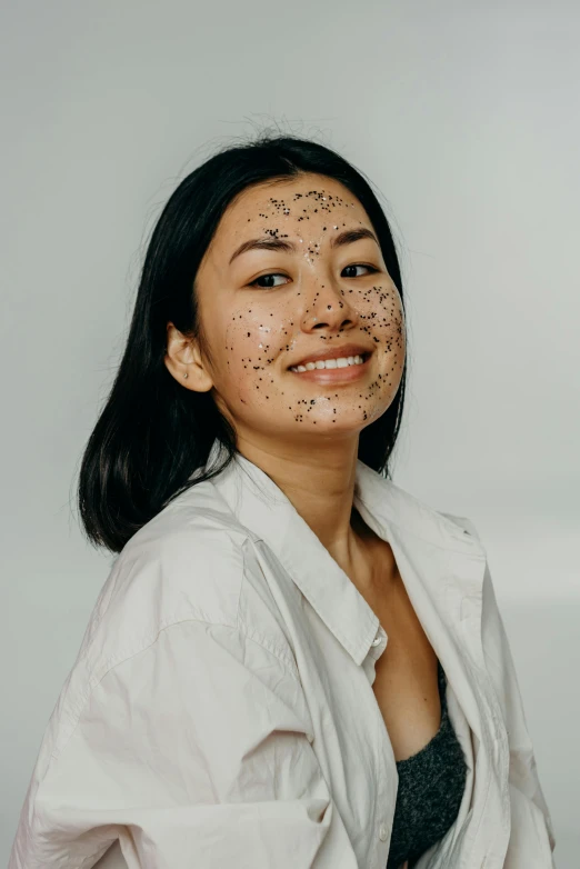 a woman with black spots on her face, inspired by Ruth Jên, reddit, photoshoot for skincare brand, looking happy, rice, speckled